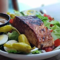 Grilled salmon and salad on a white plate.